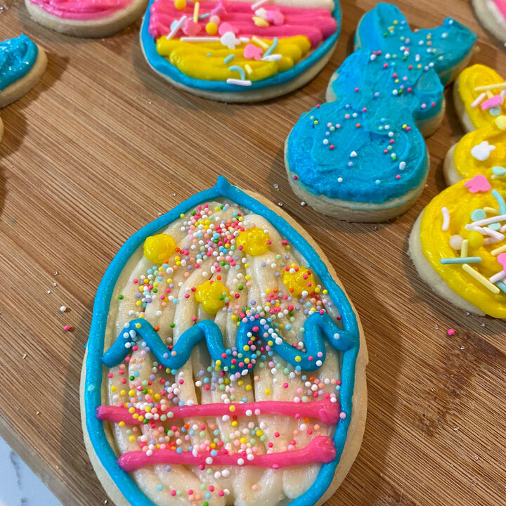 Easter sugar cookies decorated with bright icing and sprinkles on a wooden board